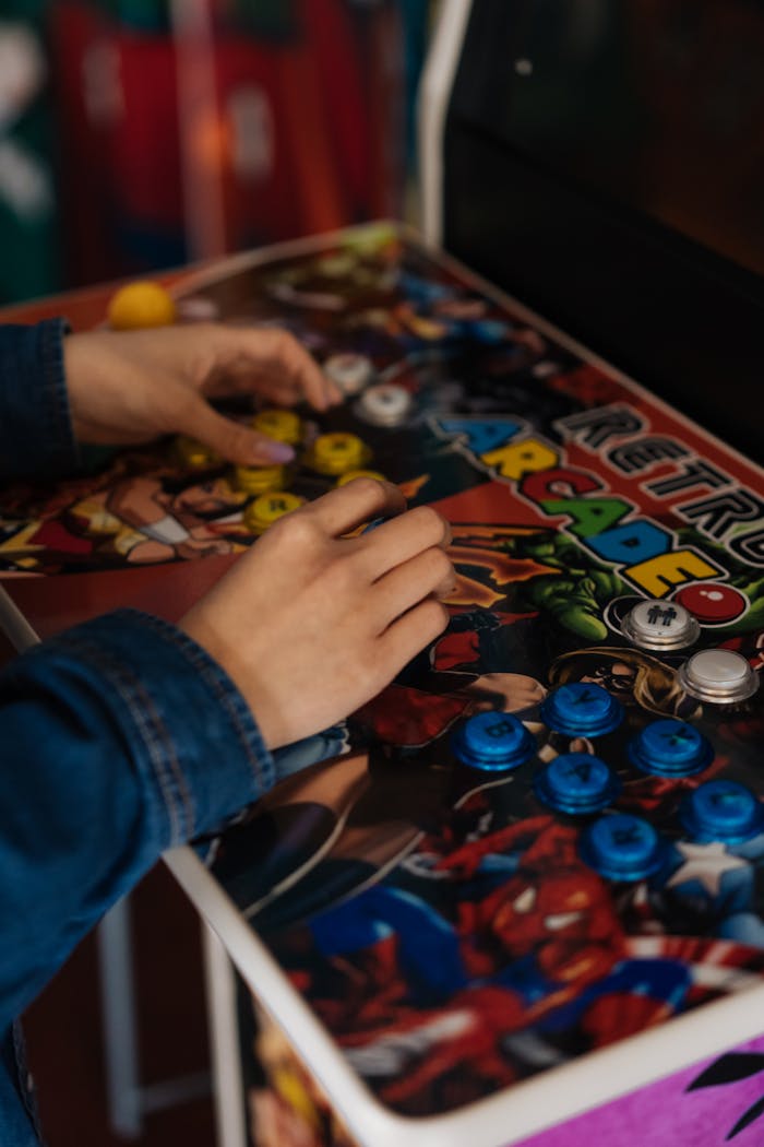 Close-up shot of hands playing a retro arcade game with colorful buttons. Nostalgic gaming experience.